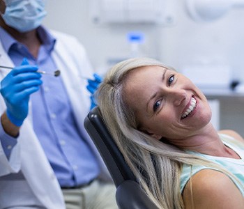Woman smiling while sitting in dentist treatment chair