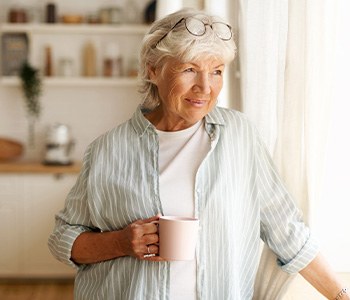 Woman having cup of coffee while looking out window