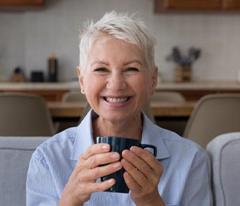 Woman smiling while holding a coffee mug