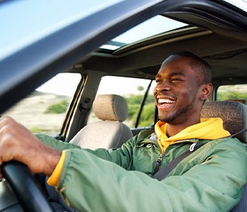 Man smiles while driving