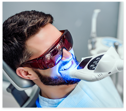 Man in dental chair getting professional teeth whitening