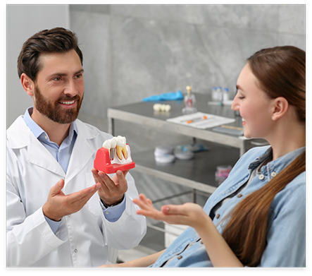 Dentist showing a dental implant model to a patient