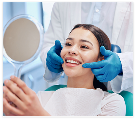 Dental patient looking at her new smile in mirror