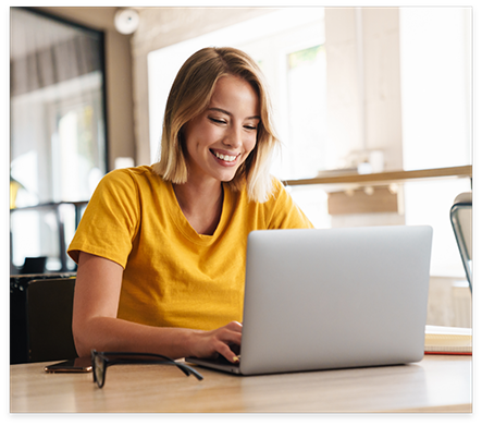 Woman smiling while using laptop at table