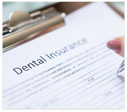 Person filling out dental insurance paperwork on clipboard