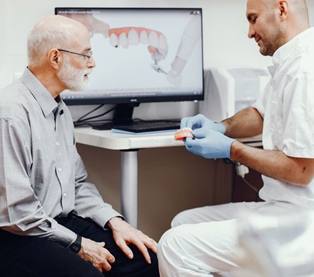 Dentist and patient sitting in front of a computer, talking