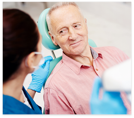 Senior man in dental chair listening to his dentist