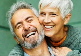 Senior man and woman hugging after receiving dental services in Nocatee