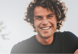 Smiling young man with curly brown hair