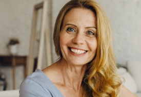 Smiling blonde woman sitting on couch
