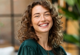 Woman with curly brown hair grinning