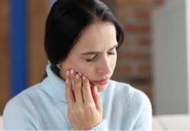 Woman holding her cheek in pain
