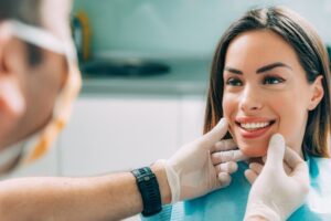 A young woman smiling during a dental check-up. 