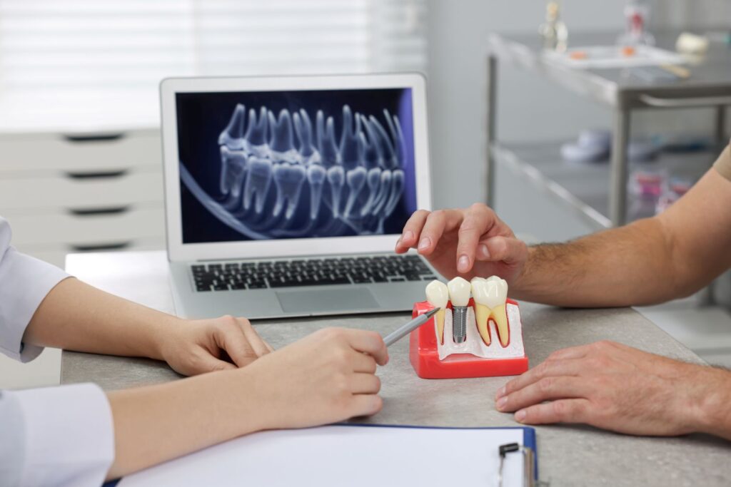 A dentist showing a patient a model of a dental implant